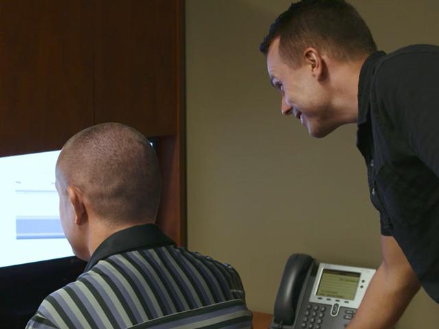 Two male engineers working at a computer